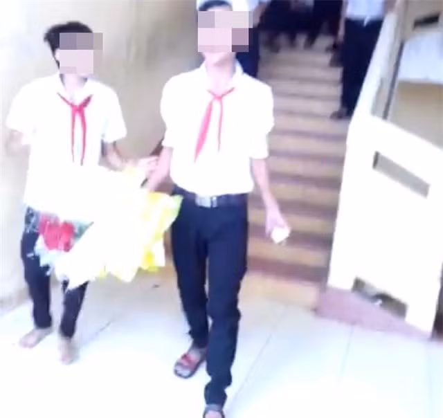 Chàng trai cầm bó hoa bước từ trên tầng xuống. (Ảnh cắt từ clip)