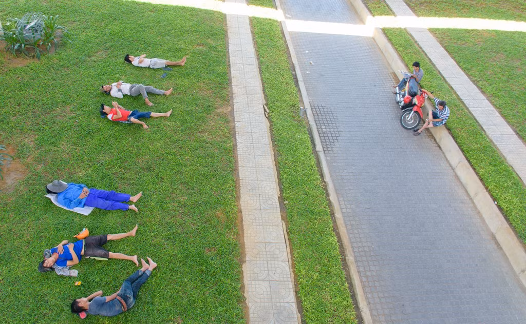 Để tránh cái nóng như thiêu đốt, nhiều người dân đã ra gầm cầu vượt ngã 3 Huế để nằm dưới các bãi cỏ ngủ trưa thay vì ở nhà như thường lệ.