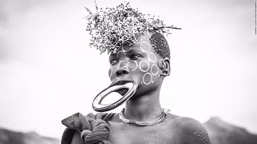 Phụ nữ của bộ lạc Suri nổi tiếng với việc căng môi với những chiếc vòng hoặc đĩa làm bằng đất sét nung. Khi các cô gái đến tuổi dậy thì, họ sẽ trải qua một nghi lễ dị thường, trong đó 2 chiếc răng hàm dưới bị nhổ bỏ trước khi môi dưới của họ được đục thủng một lỗ nhỏ. Một chiếc đĩa bằng đất sét hoặc tấm gỗ sẽ được gắn chặt vào lỗ thủng trên môi và lỗ thủng này sẽ dần dần gia tăng kích cỡ, kéo giãn môi dưới một cách bất thường.