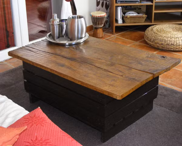 Nguyên liệu để làm ra chiếc bàn này chỉ có một chiếc thùng cũ bỏ đi, bạn đem sơn màu tùy theo sở thích, có thể là màu đen như trong hình. Và một tấm ván phẳng, bạn chỉ cần đóng ghép lại là tạo ra một cái bàn uống nước.Ngoài ra, bạn cũng có thể tận dụng khoảng trống bên trong thùng gỗ để đựng vài vật dụng như cốc, chén. Đây là cách làm vừa tiết kiệm chi phí vừa giữ được tính thẩm mỹ riêng cho căn phòng của bạn.