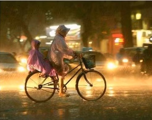 "Mẹ không có ôtô, không có xe máy, nhưng được nấp sau lưng mẹ là hạnh phúc nhất đời con", tác giả của bức ảnh chia sẻ. Ảnh: MT.