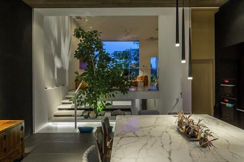 Mặt sau của ngôi nhà có một hồ bơi nhỏ ngay bên ngoài khu vực ăn uống được nép mình bên cạnh một bức tường ranh giới với cửa thông gió.