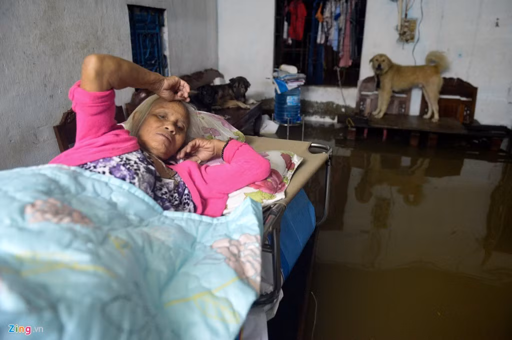 Bà Nguyễn Thị Hồng nằm trên chiếc giường đã kê cao. Quê ở Ba Vì, Hà Nội, bà sống tại Sài Gòn đã hơn 20 năm và chứng kiến quá nhiều lần lụt lội nên quen.