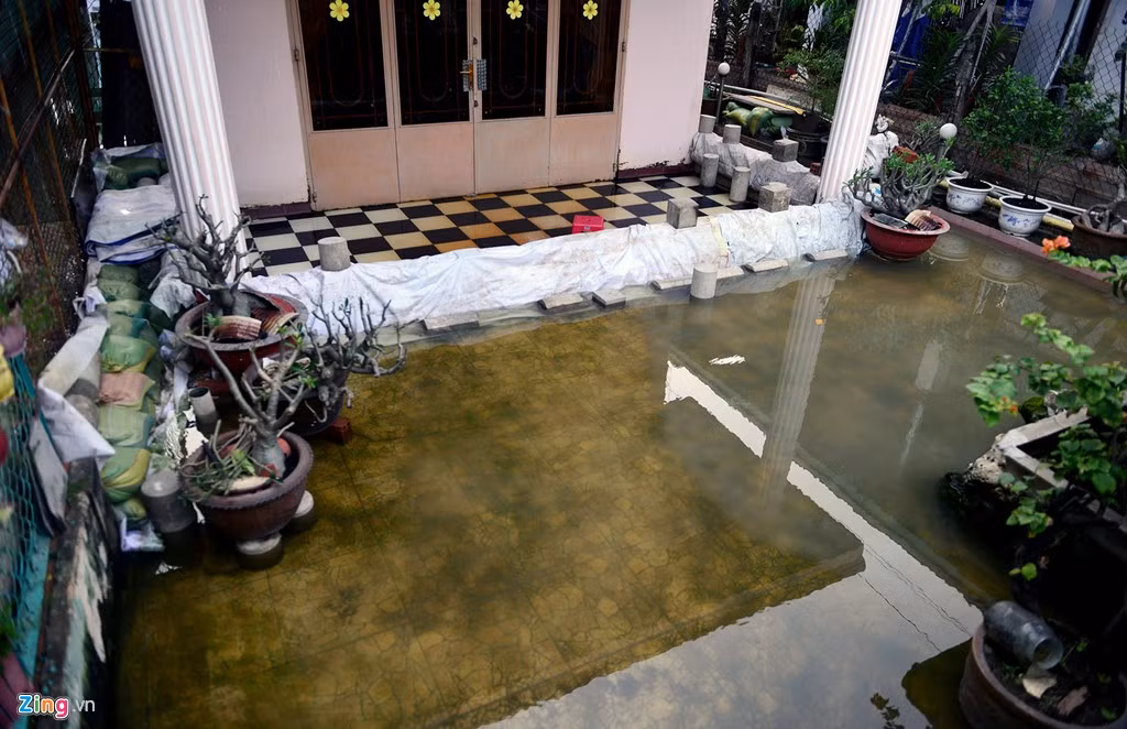 Phần lớn các gia đình phải luôn chuẩn bị sẵn bao cát, bạt để chắn nước từ sân vào nhà khi có mưa.