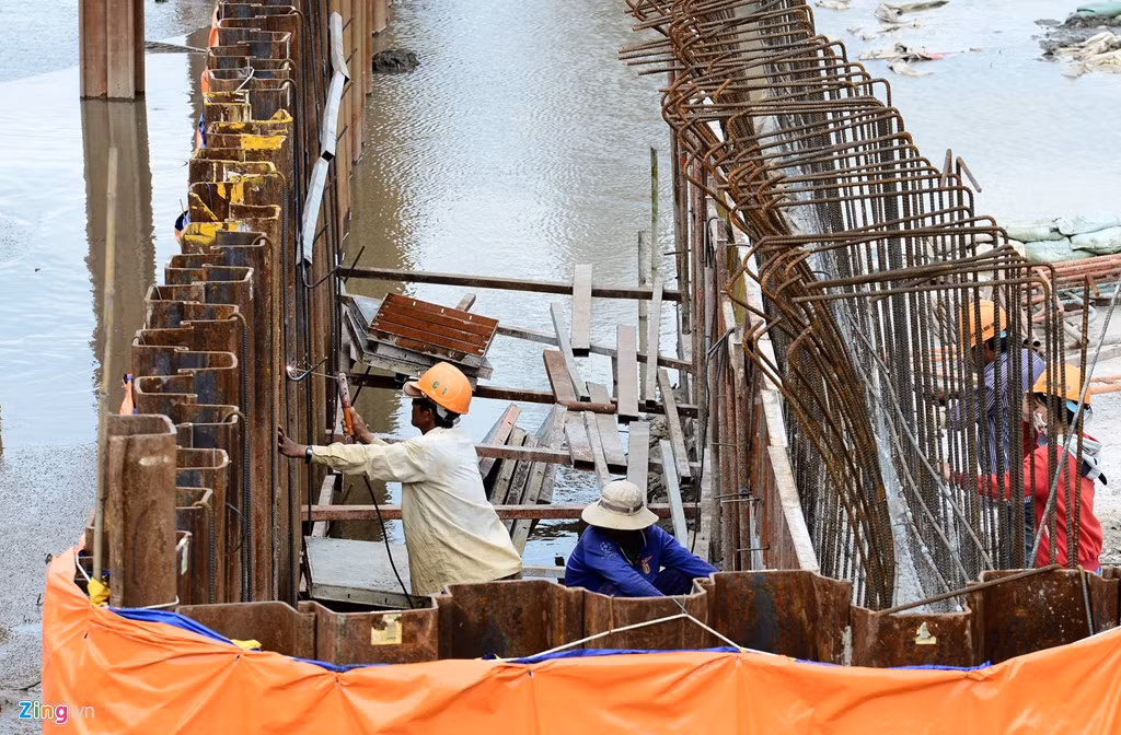 Công nhân làm việc ngay dưới lòng kênh để hoàn thiện hạ tầng dự án.