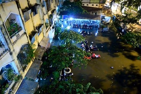 Nhiều xe máy trước sân chung cư 537 đường Phạm Văn Đồng, quận Bình Thạnh bị ngâm trong nước gần lút bánh xe .