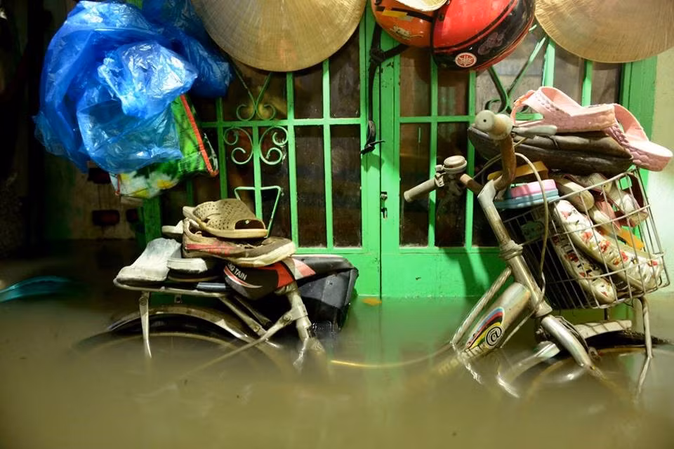 Chiếc xe đạp thành điểm cao để chất giày dép cho khỏi ướt trong nhà một hộ dân ở Thanh Đa, Bình Thạnh. Ảnh: Lê Quân.