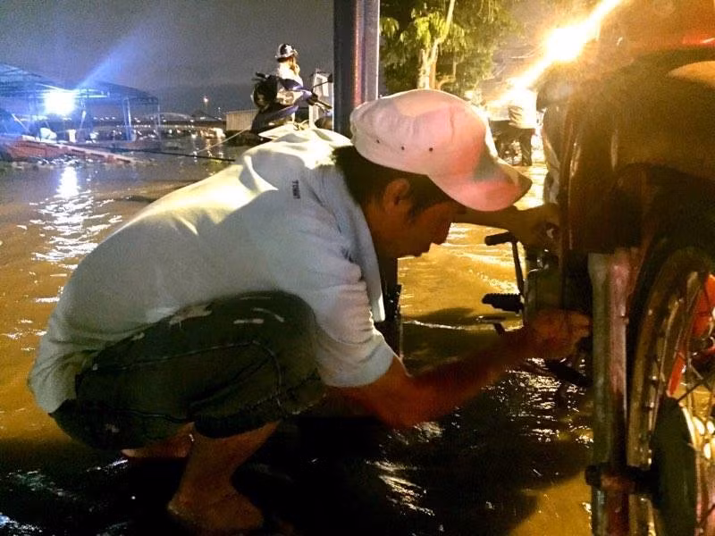 Anh Tuấn đang câu cá thấy người dắt bộ trên đường Trần Xuân Soạn, quận 7 vì ngập đã phụ sửa xe giúp. Đài Khí tượng Thủy văn khu vực Nam Bộ thông tin mực nước đỉnh triều vùng hạ lưu sông Sài Gòn – Đồng Nai sẽ tiếp tục lên trong những ngày tới và đạt đỉnh vào khoảng ngày 17 và 18/10 (ngày 17 và 18/9 Âm lịch). Ảnh: Lê Trai.
