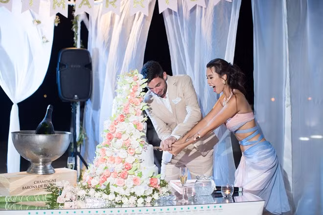 Siêu mẫu Hà Anh và chồng hạnh phúc cắt bánh trong bữa tiệc để chiêu đãi mọi người.