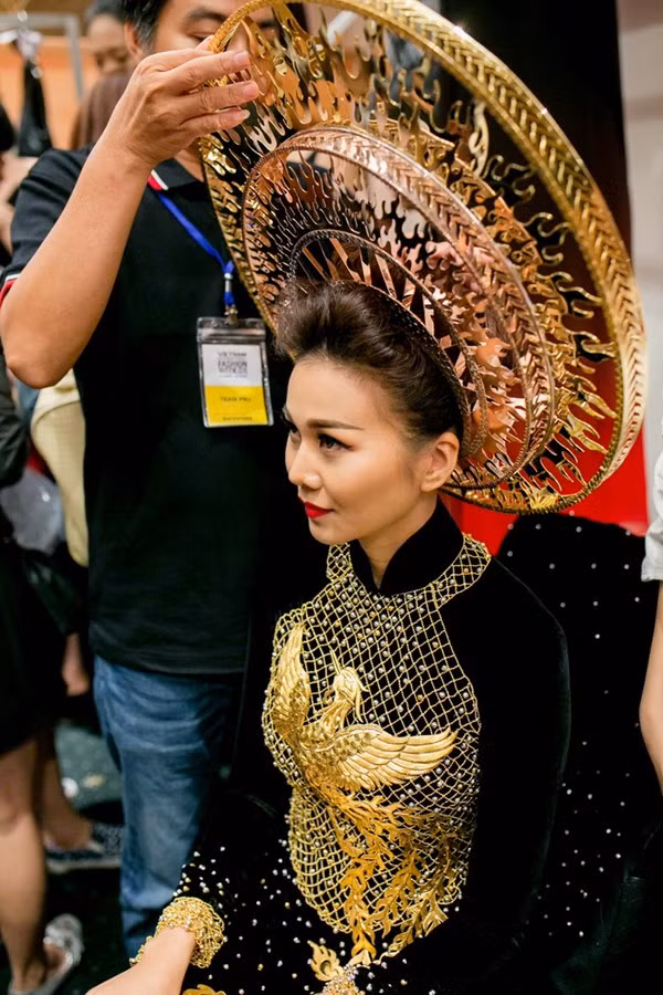 Đây là chiếc áo dài với họa tiết dát vàng tinh xảo, thể hiện tinh thần Việt Nam truyền thông. Ý tưởng của chiếc áo dài này chính là từ hình tượng chim Phượng Hoàng, linh vật thanh cao biểu trưng cho đức hạnh cùng những giá trị cao quý của người phụ nữ. Được biết chiếc áo dài trị giá 1,2 tỉ đồng được chế tác từ 24 lượng vàng với hơn 2.000 chi tiết tinh xảo, do 30 nghệ nhân kim hoàn thực hiện hoàn toàn bằng phương pháp thủ công trong suốt 240 giờ đồng hồ.