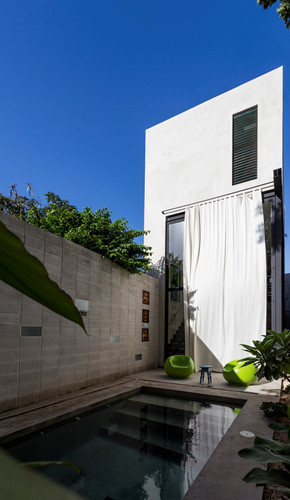 Một bức tường màu xanh lá cây ở phía Tây tăng cường các rào cản nhiệt, tránh nước quá nóng khu vực sân trung gian là các quá trình chuyển đổi từ việc tiếp cận khu vực sinh sống và đến sân bên trong của phòng ngủ.