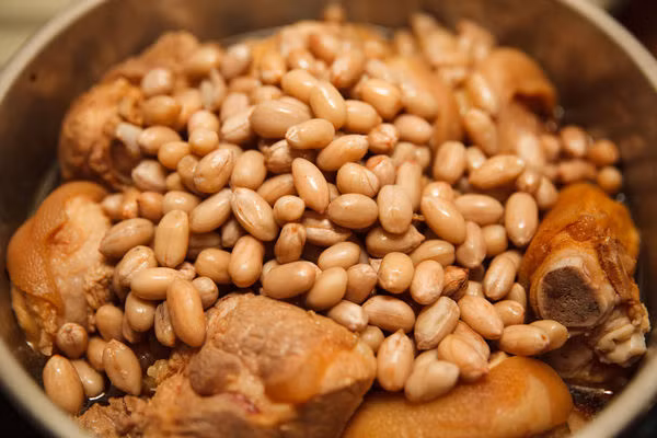 - Đậu phộng luộc trong 10 phút rồi vớt ra bỏ vào nồi cùng với chân giò.