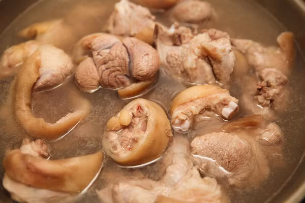 Cách làm: - Chân giò cạo lông, rửa sạch, chặt miếng vừa ăn, trụng qua nước sôi để loại bỏ hết chất bẩn.