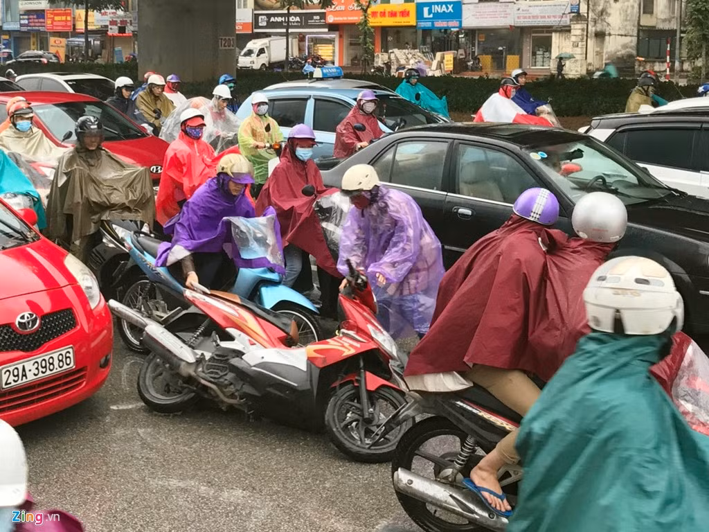 Một phụ nữ đi xe máy bị chiếc ôtô đâm nhẹ từ phía sau ngã lăn ra đường. Ảnh: Tiến Tuấn.