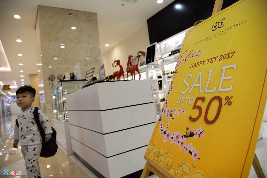 Các cửa hàng vẫn trưng bày và trang trí các biển hiệu giảm giá sản phẩm từ trước Tết.