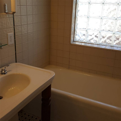 Bồn tắm trong phòng tắm duy nhất tại Bảo tàng Nhà Clintons với màu trắng chủ đạo và cửa sổ lớn để tạo cảm giác rộng và thoáng.