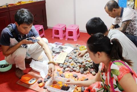 Chủ gian hàng chứng minh cho người tiêu dùng thấy đá nổi trên mặt nước. Ảnh báo Lào Cai