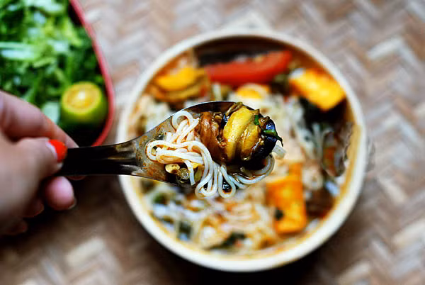 Bún ốc Trong những buổi sáng thu hơi se lạnh thế này, được ngồi xì xụp một tô bún ốc nóng hổi, nước dùng có đủ vị chua, cay, thanh, quả khó có gì sánh bằng. Bát bún ốc đúng chuẩn không có bò, không giò, chả, đậu mà chỉ có những con ốc béo, miếng cà chua đỏ, hành, tía tô xanh điểm cùng chút mắm tôm tím nhạt, thế mà đố ai không thèm thuồng. Húp một thìa nước dùng nóng hổi, ta sẽ cảm nhận rõ được vị thanh của nước, vị tê tê của ớt, vị chua, thơm của dấm bỗng, ta mới hiểu vì sao bún ốc lại khiến người ta thèm thuồng nhiều đến thế khi trời lạnh về.