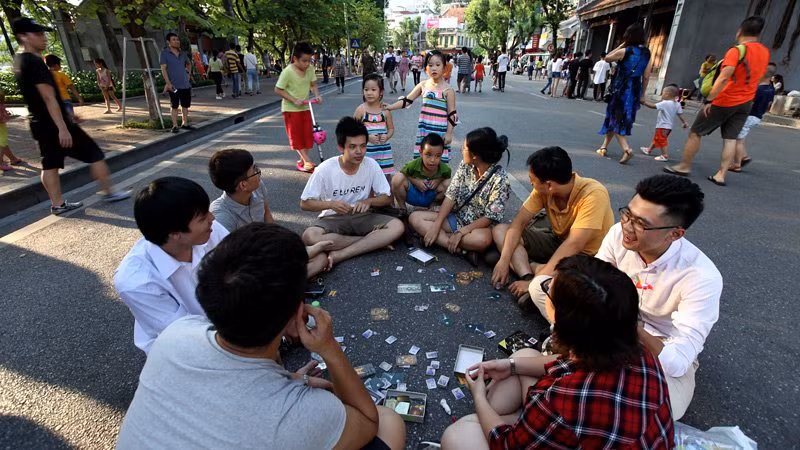 Nhóm thanh niên ngồi giữa lòng đường phố Đinh Tiên Hoàng chơi bài.