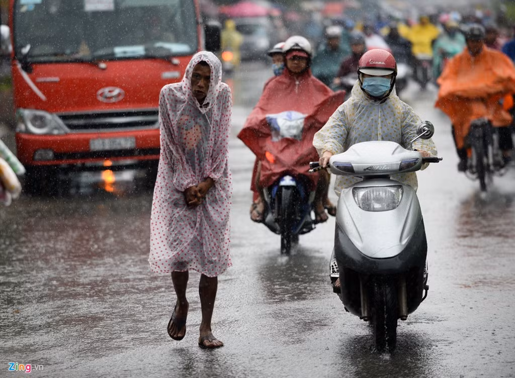 Người đàn ông khúm núm đi giữa trời mưa trên đường Điện Biên Phủ, quận Bình Thạnh.