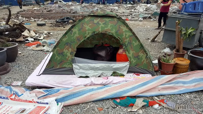Một gia đình phải dựng lều tạm qua đêm trong lúc thu dọn đồ đạc.