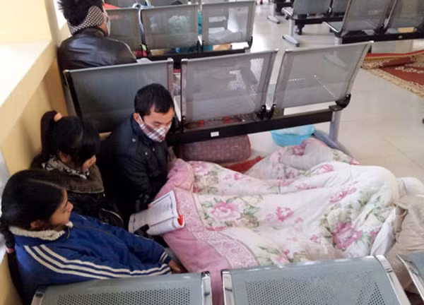 Người nhà bệnh nhân co ro trong một góc, trùm chăn, đọc sách... để quên đi cái lạnh.