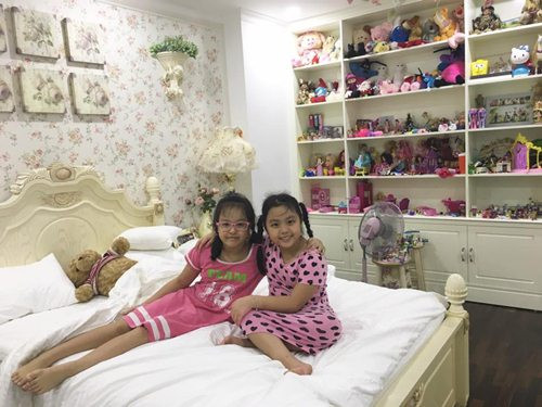 Hai chị em ở chung 1 phòng và có 1 giá đựng đồ chơi rất lớn.