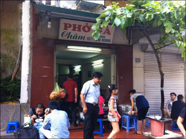 4. Phở gà Yên Ninh (63 – Yên Ninh, Ba Đình) Quán phở được mệnh danh là “đắt nhất Hà Nội” này lại có nét đặc biệt hấp dẫn khách hàng. Tô phở đầy đặn, nhiều hơn hẳn các quán khác, thịt gà ta dai, thơm, nếu khách có như cầu sẽ được ăn thêm tim, trứng, đùi, cánh gà... Tất nhiên mức giá sẽ khác. Tuy đắt đỏ (60k/bát phở gà trắng) nhưng nhiều người tới đây ăn lại cho là “đắt xắt ra miếng”, vì hiếm nơi đâu làm được bát phở đậm vị, ngon miệng, mà thái độ phục vụ của nhân viên cũng rất lễ phép, tế nhị như thế.