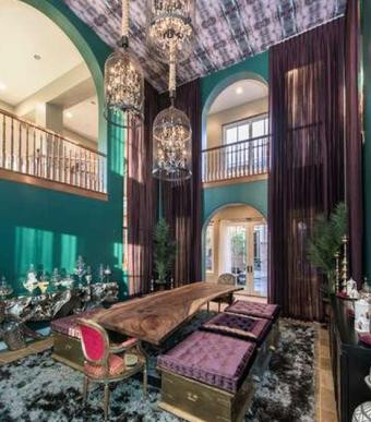 Phòng ăn có bàn gỗ dài để màu mộc. Màu chủ đạo là xanh lá và tím sang trọng.