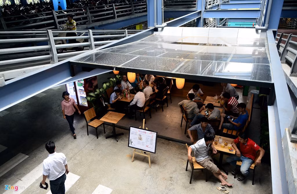 Một quán cà phê nhỏ được mở dưới phần dốc lên xuống khu vực để xe máy.