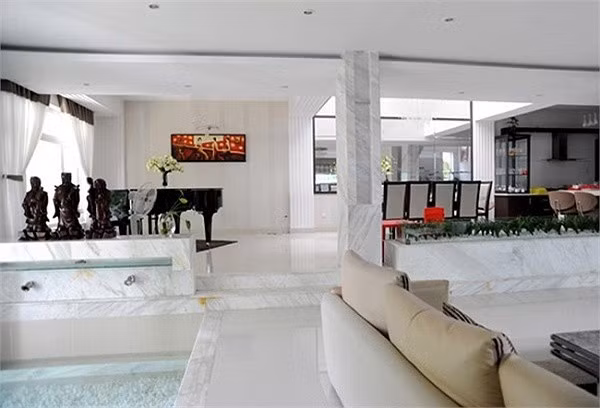 Tầng một có thiết kế liên thông giữa phòng khách và phòng bếp, phòng ăn. Phòng khách không trang trí rườm rà nhưng toát lên vẻ sang trọng nhờ bộ salon đắt tiền.