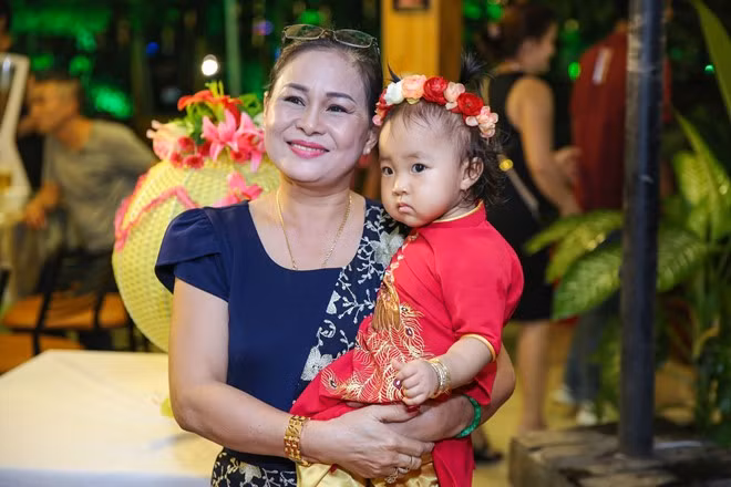 Bà ngoại chăm sóc bé Kim Hậu suốt buổi tiệc để con rể và con gái tiếp khách.