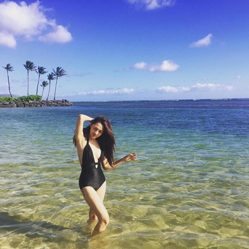 Nữ ca sĩ mặc áo tắm một mảnh màu đen quyến rũ khoe khéo hình xăm bên mạn sườn và trên đùi phải.