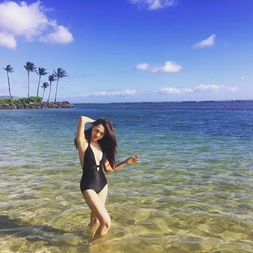 Nữ ca sĩ mặc áo tắm một mảnh màu đen quyến rũ khoe khéo hình xăm bên mạn sườn và trên đùi phải.