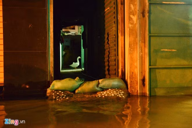 Chủ các ngôi nhà ở mặt đường phải dùng bao tải be ngăn nước tràn vào trong.