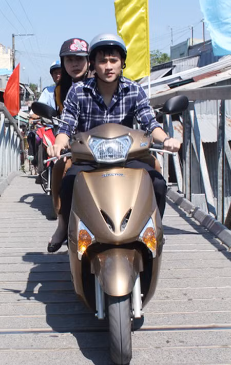 Vợ chồng Công Vinh - Thủy Tiên đi xe máy, tự tay khuân từng bao gạo phát cho người nghèo.