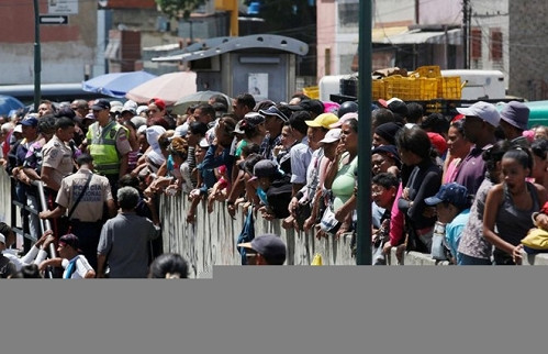 Mọi người tụ tập bên ngoài một siêu thị ở thủ đô Caracas để chờ mua lương thực và nhu yếu phẩm. Để mua được đồ, nhiều người đứng xếp hàng từ đêm hôm trước. Không ai biết siêu thị sẽ bán gì.