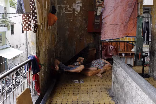 Hiện tại chung cư Cô Giang vẫn còn khoảng 300 hộ dân sinh sống. Trong ảnh: Người dân mang võng, chiếu ra hành lang ngủ để tránh cái nóng ban trưa.