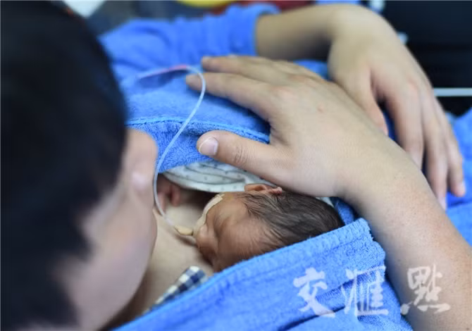 Cha hai đứa trẻ là ông Lý 31 tuổi và ông Phan 25 tuổi đã ôm ấp con trong lòng mình trong 2 giờ liền. Liệu pháp Kangaroo là một trong những liệu pháp chăm sóc trẻ sinh non nhằm giúp trẻ tiếp xúc với thân thể của cha mẹ mình để cảm nhận được hơi thở, nhiệt độ thân thể cũng như nhịp tim của cha mẹ. Nhờ đó, nhịp tim, hơi thở và thân nhiệt của bé sẽ bớt bất an và ổn định dần nên bé sẽ bớt thời gian phải nằm viện. Được biết từ đầu năm đến nay, bệnh viện này đã mạnh dạn áp dụng liệu pháp “cha Kangaroo” cho 10 trường hợp sinh non và đều thành công tốt đẹp.