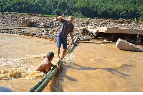 Cầu bị phá hủy, người dân phải bắc cầu tạm để qua suối.