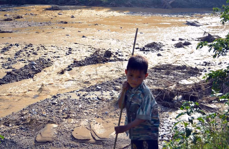 Một cậu bé thẫn thờ sau trận lũ.