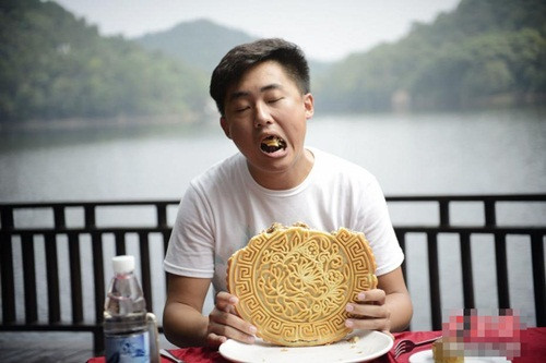 Một người chơi nhắm mắt nhắm mũi để ăn bánh trung thu.