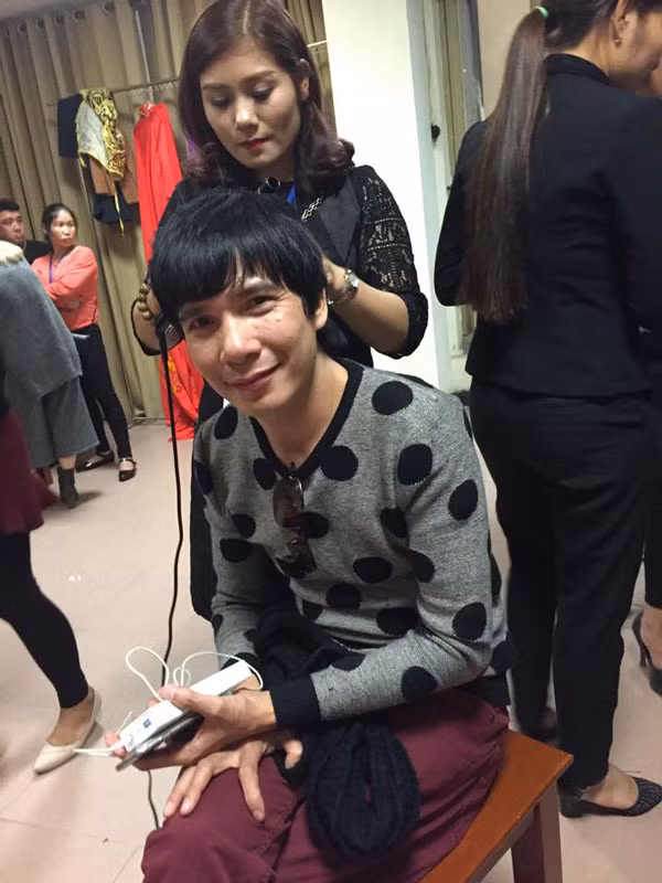 Ca sĩ Hồ Quang Tám đang được làm tóc chờ đến tiết mục biểu diễn.