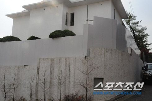 Biệt thự hai tầng sơn màu trắng được xây tường quây kín.