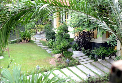 Bên trong căn biệt thự, thiết kế tiểu cảnh tinh tế với khu vườn xanh mát và đường đi lát đá trông rất thanh bình.