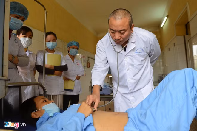 Hàng ngày, sau khi giao ban, bác sĩ Hưng lần lượt đi thăm khám cho các bệnh nhân. Trong ảnh là chị Nguyễn Thu Hằng (tên đã được thay đổi), người Yên Bái. Người phụ nữ 29 tuổi này lập gia đình từ năm 2008 (có con gái 7 tuổi may mắn khỏe mạnh) và bị lây nhiễm từ chồng ngay sau đó một năm. Chồng Hằng từng nghiện hút và nhiễm HIV, cũng từng nằm tại Bệnh viện 09 và qua đời năm 2011.