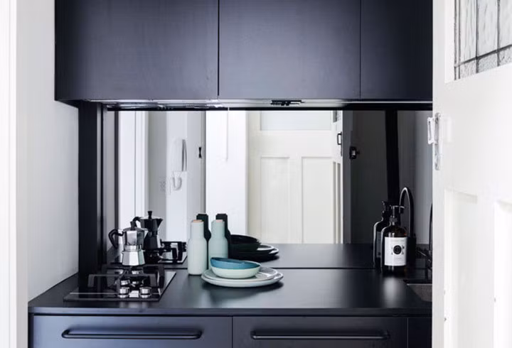 Nhà bếp được thiết kế chủ đạo là màu đen và với các bề mặt mờ tạo nên sự thanh lịch, sạch sẽ. Tủ bếp được che phủ bằng gương, tạo cho căn phòng cảm giác lớn hơn, đây là sự kỳ diệu mà các kiến trúc sư đã tạo ra trong ngôi nhà này.