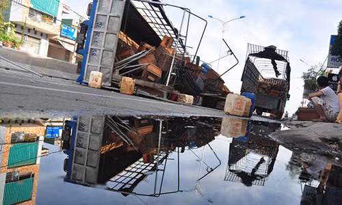 Xe tải lật nghiêng, hàng trăm lít dầu và mật ong tràn trên quốc lộ 1. Ảnh: Minh Hoàng.