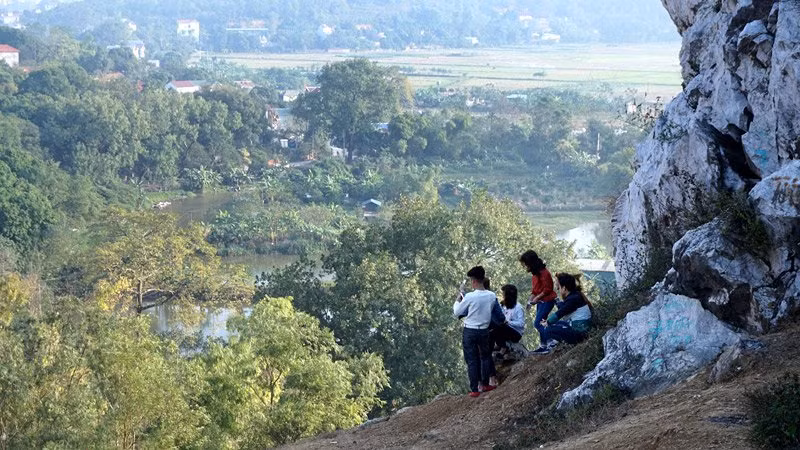 Nhiều học sinh, sinh viên thích thú với cảnh quan uốn lượn của dòng sông Đáy, thảm lúa xanh mướt, khu dân cư san sát phía dưới núi Trầm.