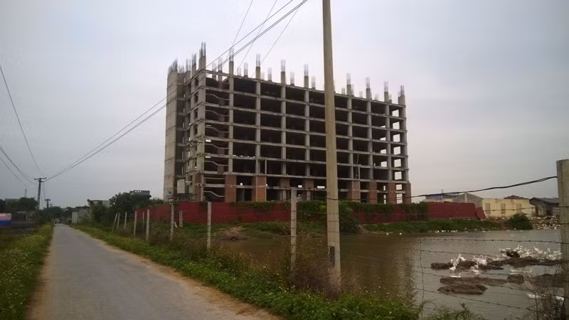 Công trình nhà ở SV nhìn từ phía xa là một tòa tháp bỏ hoang với sắt thép ngổn ngang nằm giữa trời. (Ảnh: Phong Trần)